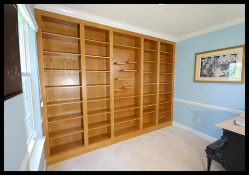 Custom 5-tier Red Oak built-in bookcase with a specialized center section featuring floating shelving.